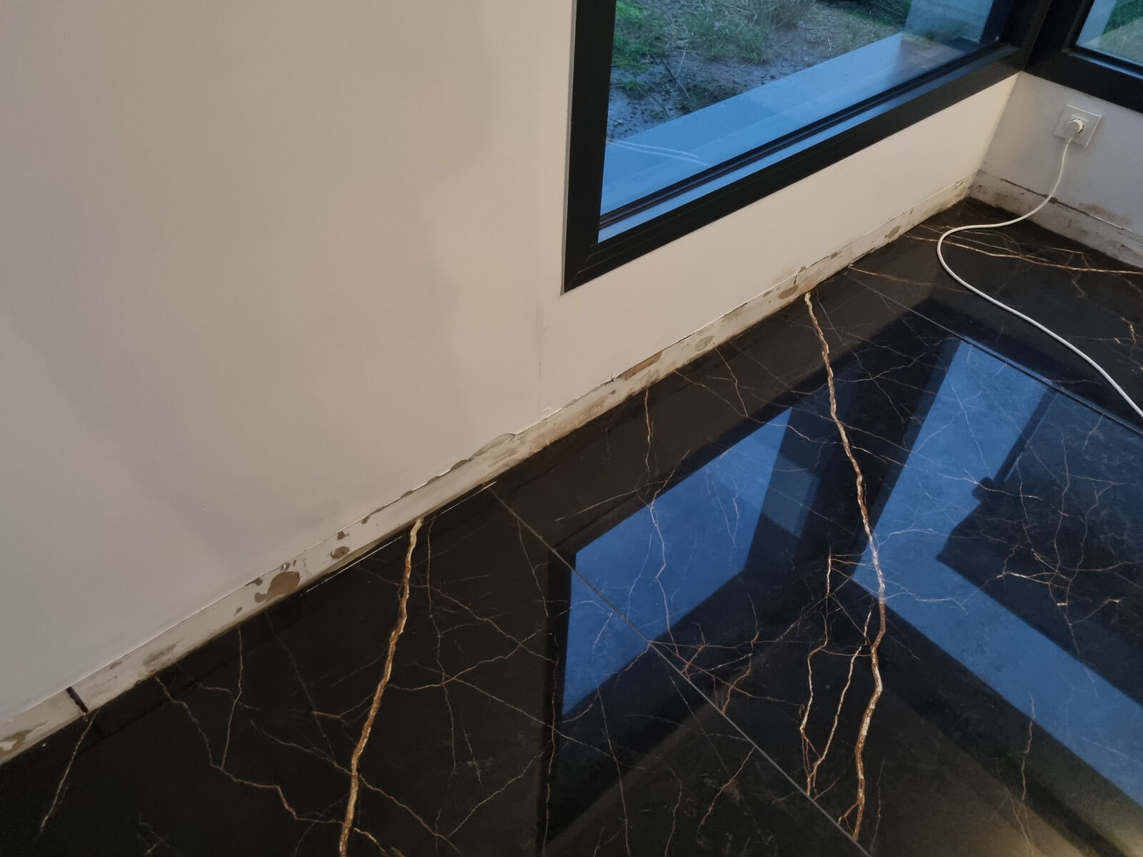 Avant rénovation — mur gorgé d'humidité après infiltration en dalle dans une villa de Biarritz