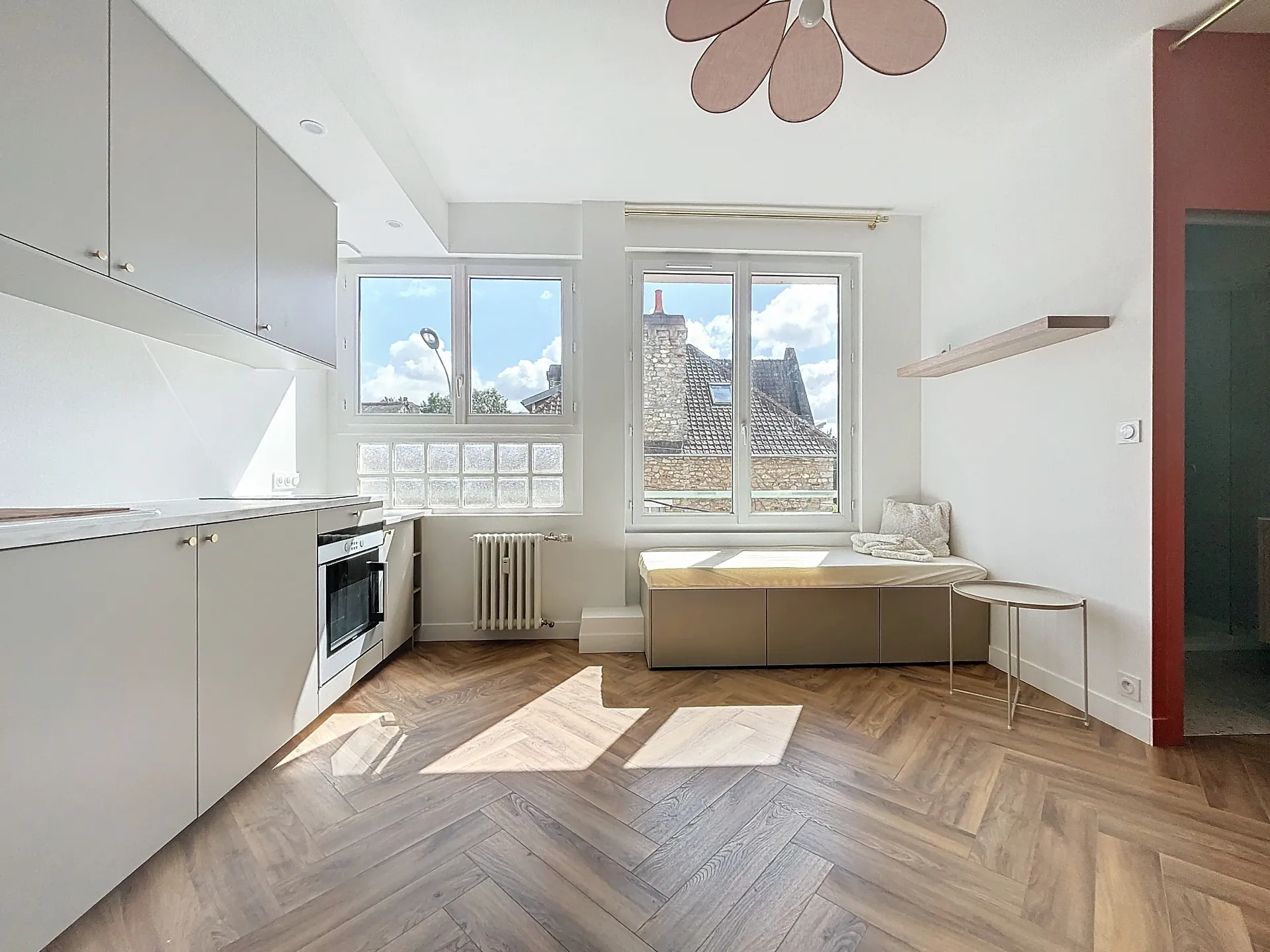 Cuisine équipée avec parquet chevrons et vue sur les toits de Bayonne