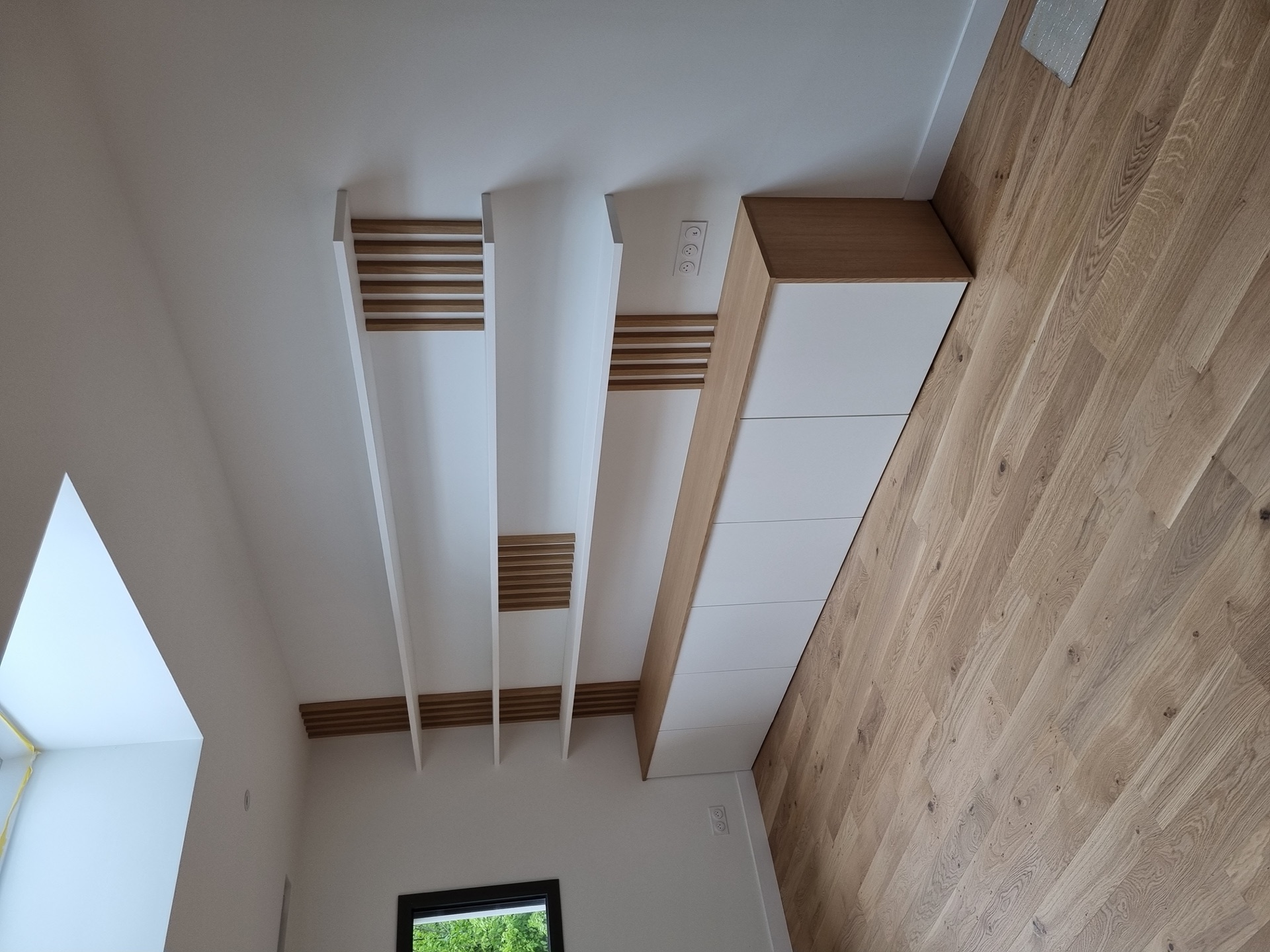 Étagères blanches à fixation invisible et tasseaux chêne verticaux dans une maison rénovée à Biarritz