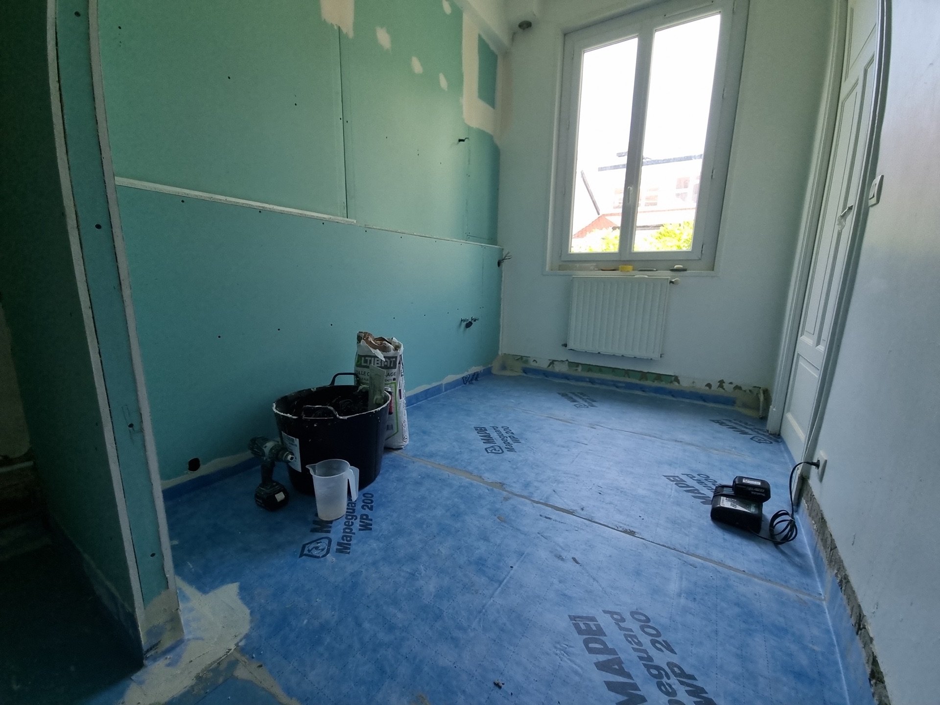 Pose d'une nappe d'étanchéité Mapei WP 200 au sol d'une salle de bain à Biarritz pour garantir une étanchéité durable