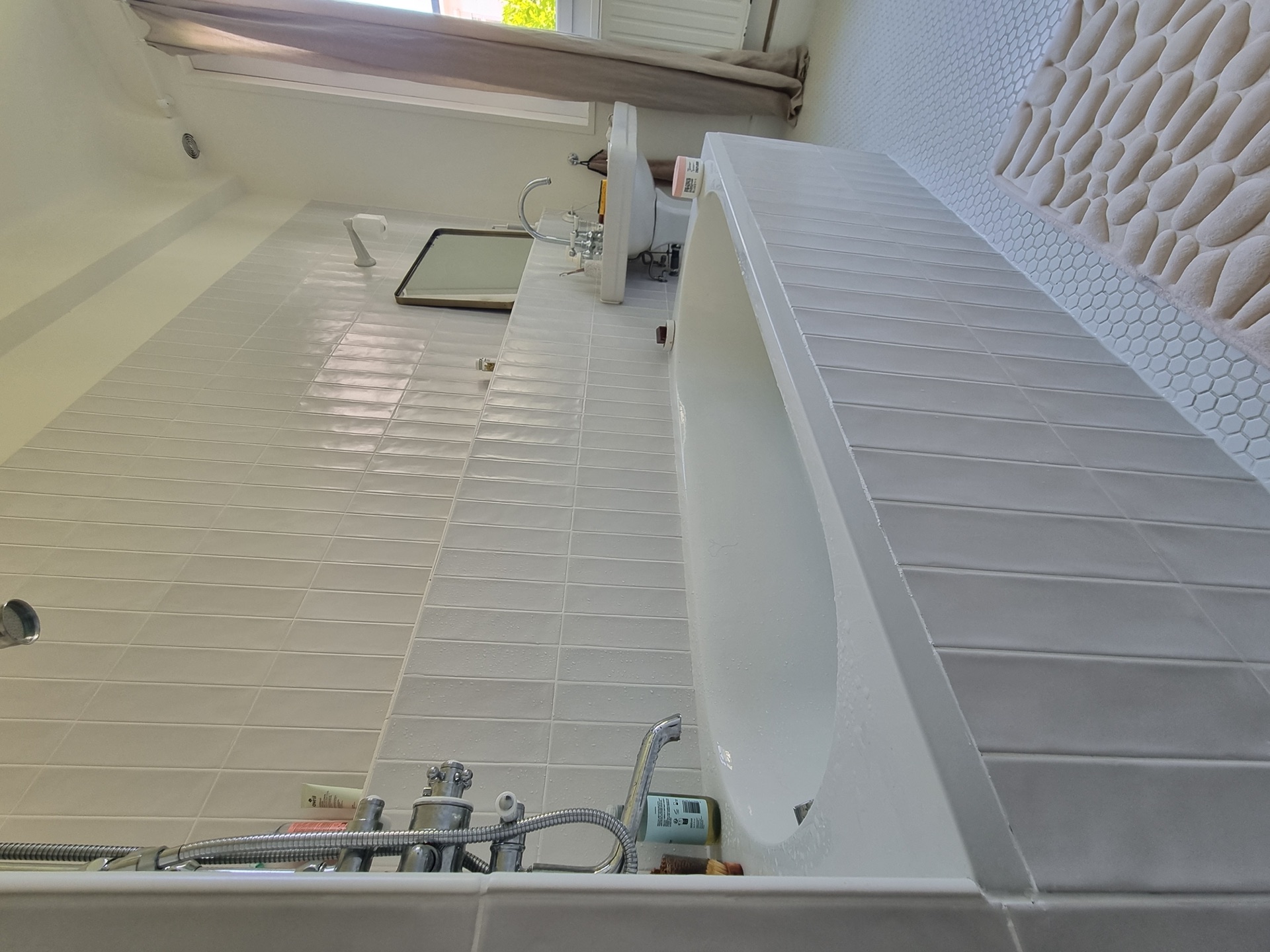 Vue d'ensemble d'une salle de bain rénovée à Biarritz centre avec baignoire, vasque colonne et carrelage métro