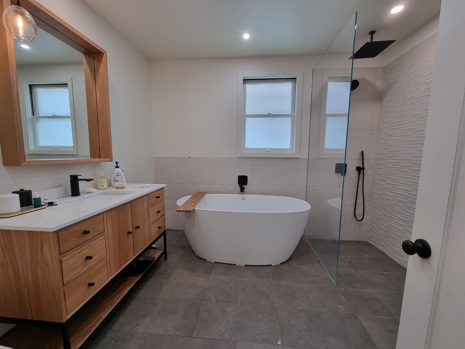 Salle de bain rénovée à Bayonne - baignoire îlot, meuble vasque en bois sur-mesure et douche à l'italienne
